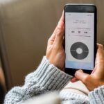 Woman lying down listening to streamed music from her phone