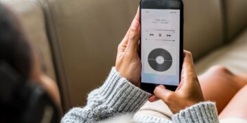 Woman lying down listening to streamed music from her phone