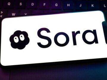 Sora logo on a smartphone resting on a laptop